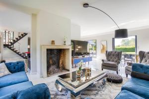 ein Wohnzimmer mit blauen Sofas und einem Kamin in der Unterkunft Villa Azif - Superbe Maison avec Piscine - St Pierre Azif in Saint-Pierre-Azif