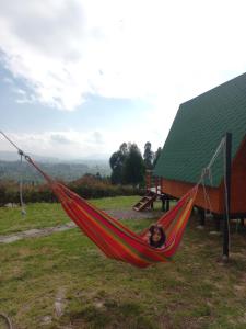 uma mulher deitada numa rede num campo em Cabaña el Gran Cañon em Paipa