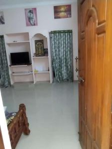 Habitación con puerta, TV y habitación en P. G. REDDY HOME STAY en Tirupati