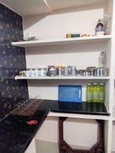 uma cozinha com um balcão e prateleiras com panelas e frigideiras em P. G. REDDY HOME STAY em Tirupati