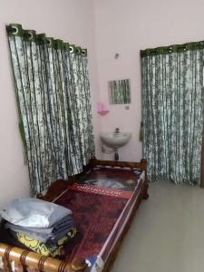 P. G. REDDY HOME STAY في تيروباتي: حمام مع سرير ومغسلة في الغرفة