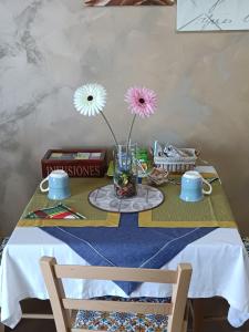 einen Tisch mit einer Vase mit Blumen darin in der Unterkunft Panoramic in Troina