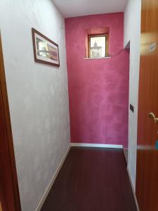 a hallway with a purple wall and a window at B&b Panoramic in Troina