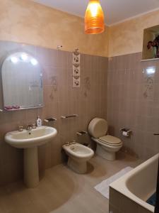 ein Badezimmer mit einem Waschbecken, einem WC und einem Spiegel in der Unterkunft Panoramic in Troina
