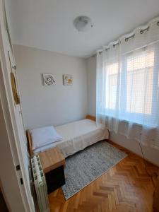 a small bedroom with a bed and a window at Apartman Iadera in Zadar