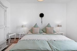 a white bedroom with a large bed with pillows at Haus Bergruh Fuchsbau in Todtnauberg