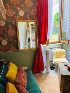 un soggiorno con divano e specchio di L’Hortense a Oloron-Sainte-Marie