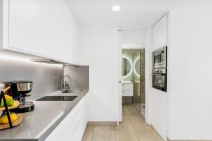 uma cozinha com armários brancos e uma bancada em MEDANO4YOU Charly Blau em El Médano