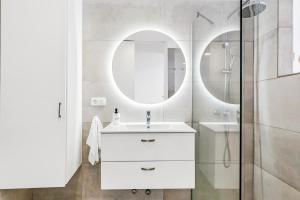 uma casa de banho branca com um lavatório e um espelho em MEDANO4YOU Charly Blau em El Médano