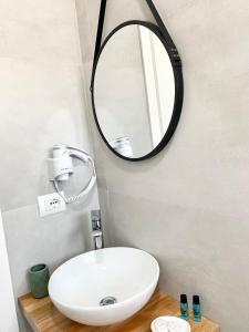 uma casa de banho com um lavatório branco e um espelho. em Villa Saral Mar em Saranda