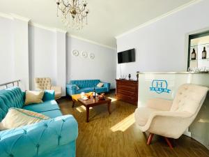 una sala de estar con muebles azules y blancos y una lámpara de araña. en HOTEL AiSi აისი en Kutaisi