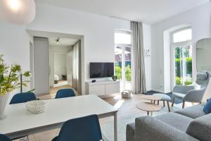 ein Wohnzimmer mit einem Sofa, einem Tisch und Stühlen in der Unterkunft Lüttjeod Apartmentvilla Lüttjeod Apartmentvilla 06 in Langeoog