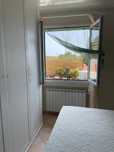 a bedroom with a window with a radiator and a table at Casa Ilaria in Diano Marina