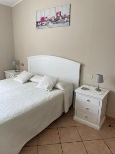 um quarto com uma cama e uma mesa de cabeceira com um candeeiro em Casa Ilaria em Diano Marina