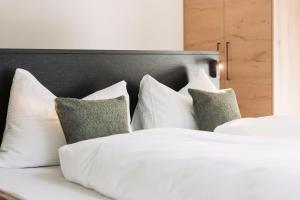 1 dormitorio con 2 camas con sábanas y almohadas blancas en Hotel Sunshine Superior "ADULTS ONLY" Ischgl - Kappl, en Kappl
