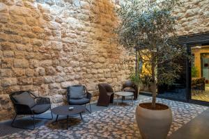 a lobby with chairs and a tree in a pot at master Bat Yam Aparthotel in Bat Yam