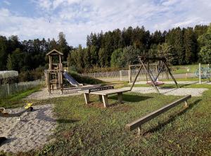 un parc avec une aire de jeux avec un toboggan et une balançoire dans l'établissement Haus Braun, à Wasserburg