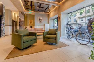 een lobby met twee stoelen en een fiets aan de muur bij OMID Saldanha Hotel in Lissabon