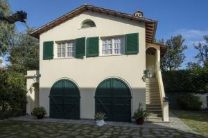 a house with green shutters on it at Villa Eden - Homelike Villas in Forte dei Marmi