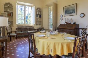 a dining room with a table with a yellow table cloth at Villa Eden - Homelike Villas in Forte dei Marmi