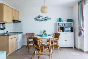 a kitchen with a table and chairs in a room at FeWo Blåkulle im Haus Seeblick - Wohnung 11 in Hohenkirchen