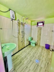 Un baño con ducha, inodoro y lavabo. en Magee apartment with kitchen and air con, en Mirissa