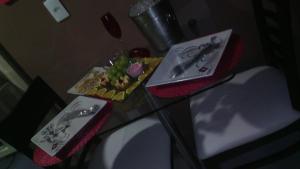 a glass table with a plate of food on it at Taj Mahal Motel in Barbalha