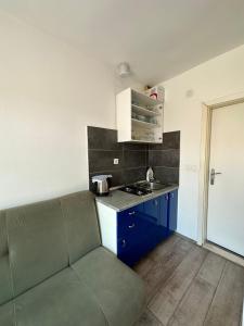una pequeña cocina con sofá en una habitación en Apartment SEAGULL, en Igrane