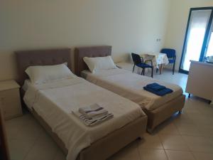 1 dormitorio con 2 camas, mesa y sillas en Vila M&D, en Divjakë