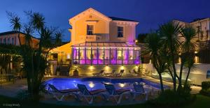 a house with a swimming pool at night at Riviera Lodge Hotel in Torquay
