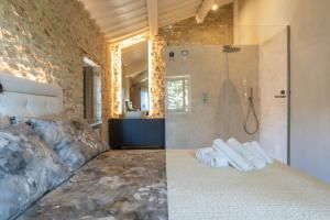 a bedroom with a shower and a bed with towels at Forma Your Boutique Suite in Corciano