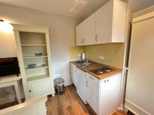 a kitchen with white cabinets and a counter top at Ferienhaus Brise - Kapitänskajüte in Wieck +6 photos
