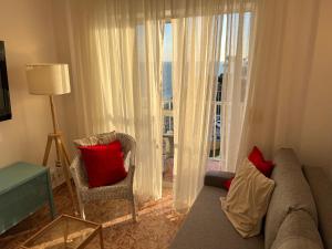 a living room with a couch and a large window at RIBERA PLAYA ALHAMAR in Sitio de Calahonda