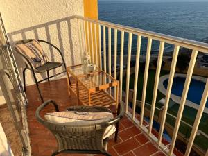 a balcony with a table and chairs and the ocean at RIBERA PLAYA ALHAMAR in Sitio de Calahonda
