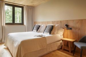 a bedroom with a large bed and a chair at Jardí d'Arties by FeelFree Rentals in Arties