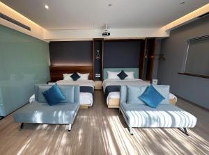 Habitación de hotel con 2 camas y 2 sillas en Villa LOHERB, en Dongshan