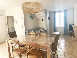 ein Esszimmer mit einem Holztisch und Stühlen in der Unterkunft FLORENTINE maison au calme proche du Port in Saint-Martin-de-Ré