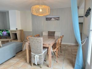 ein Esszimmer mit einem Holztisch und Stühlen in der Unterkunft FLORENTINE maison au calme proche du Port in Saint-Martin-de-Ré + 3 Fotos