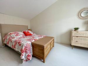 een slaapkamer met een bed met rode kussens en een tafel bij FLORENTINE maison au calme proche du Port in Saint-Martin-de-Ré