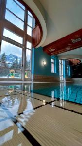 a swimming pool with a large window in a building at Un soffio d’aria sulle Dolomiti in Chiapuzza