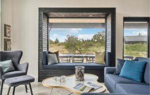 ein Wohnzimmer mit 2 blauen Stühlen und einem Tisch in der Unterkunft Lovely Home In lbk With House A Panoramic View in Ålbæk