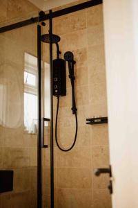 a shower with a shower head in a bathroom at The Saddle Inn, Snetterton Circuit in Norwich