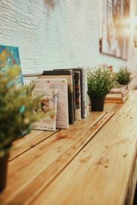 una fila de libros sobre una mesa de madera en LOFT HOSTAL Group en Lloret de Mar