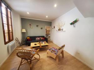 een woonkamer met een bank en een tafel bij La Louve - maison de ville in Narbonne