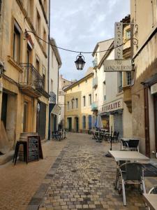 an alley with tables and chairs on a street at La Louve - maison de ville in Narbonne +12 photos
