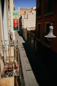 a narrow alley with buildings and a street sign at LOFT HOSTAL Group in Lloret de Mar
