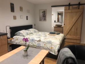 sypialnia z łóżkiem, stołem i drzwiami w obiekcie Au Mas de Mont w mieście Yvoir