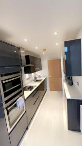 a kitchen with a refrigerator and a sink in it at Luxury 2 Bed 2 Bath Penthouse Apartment in Hendon