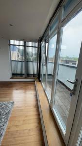 a balcony with glass doors and a wooden floor at Luxury 2 Bed 2 Bath Penthouse Apartment in Hendon