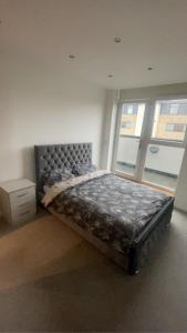 a large bed in a room with a window at Luxury 2 Bed 2 Bath Penthouse Apartment in Hendon
